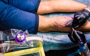 tatuador trabajando en brazo