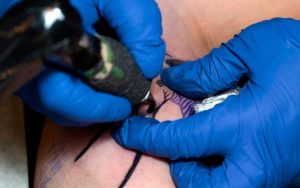 tatuador usando asepsia y antisepsia en la elaboración de tatuajes